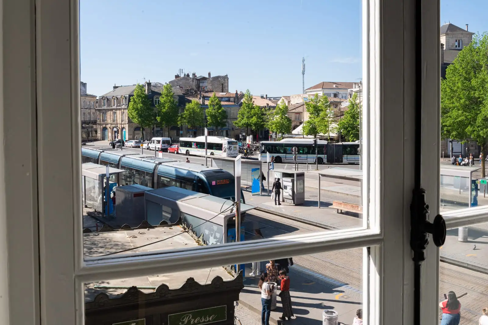 Vue sur la place de la Victoire et le tramway depuis une fenêtre de l'Atelier Qu4tre-Qu4rts à Bordeaux