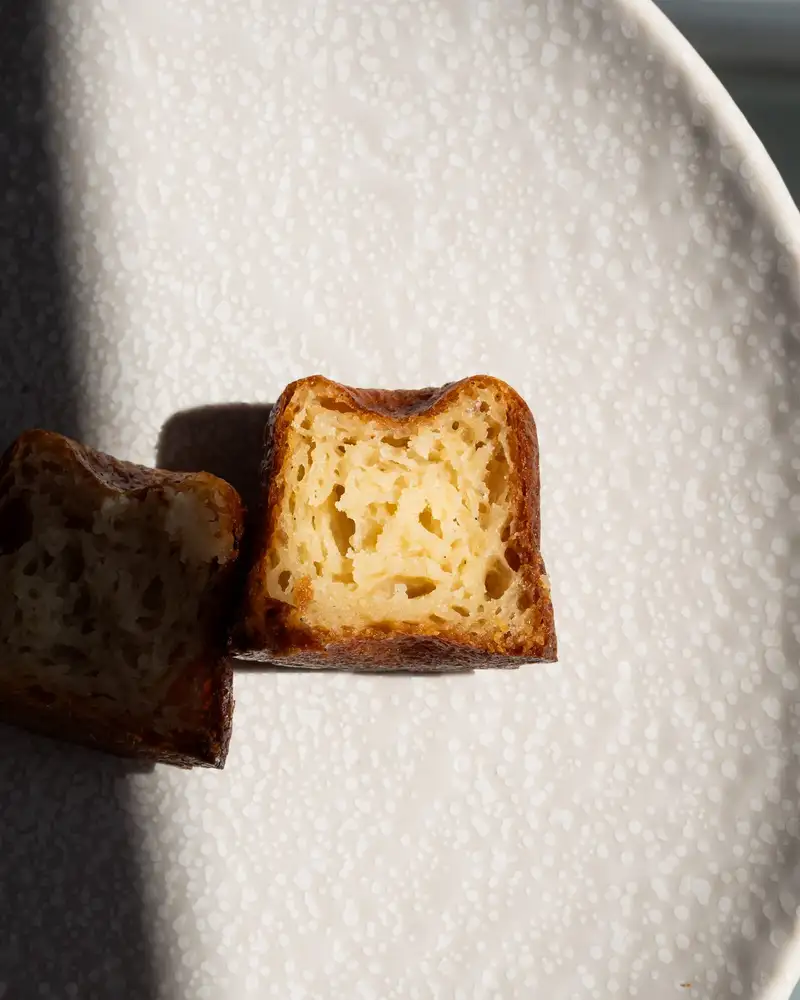 Cannelé coupé en deux, croûte caramélisée et cœur fondant, pâtisserie Quatre-Quarts à Bordeaux
