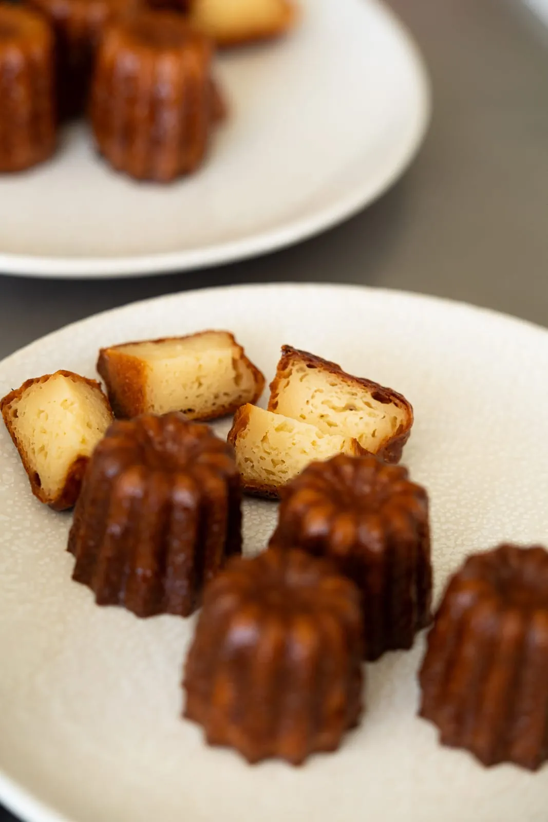 Cannelés au rhum Moon Harbour sur une assiette, croûte caramélisée, pâtisserie Qu4tre-Qu4rts à Bordeaux