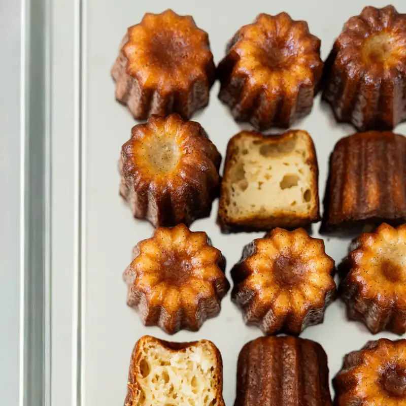 Cannelés bordelais alignés vus de dessus, dont un coupé, pâtisserie Quatre-Quarts à Bordeaux