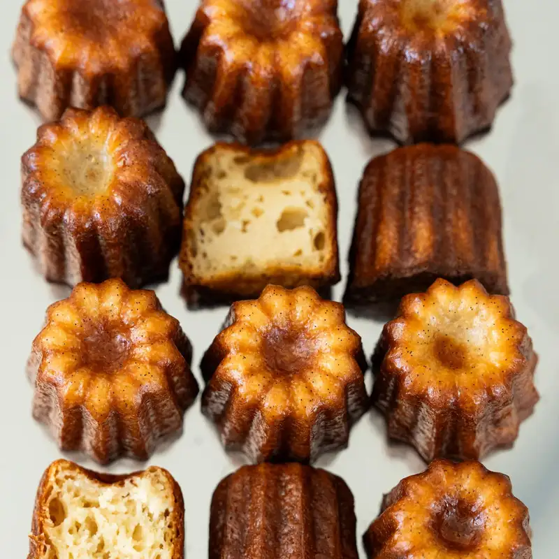 Cannelés entiers et coupés, cœur moelleux et croûte caramélisée, pâtisserie à Bordeaux