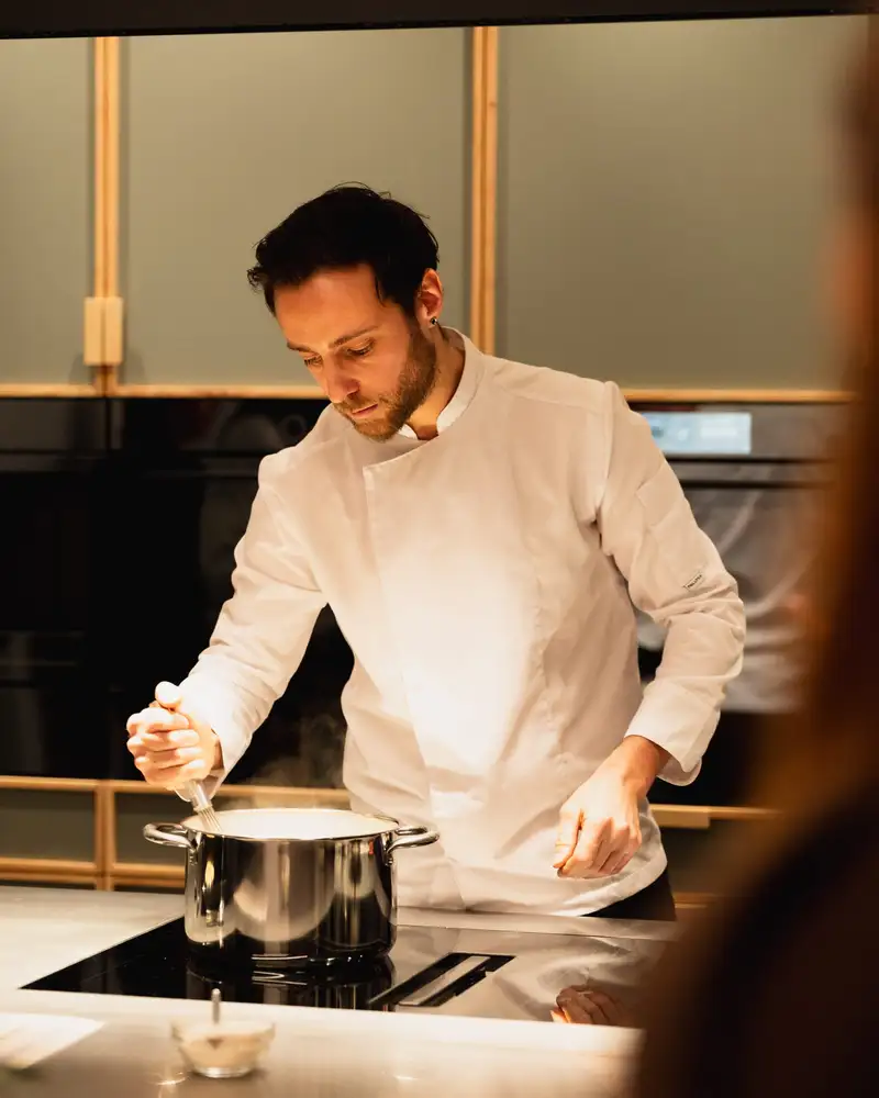 Daniel, cofondateur de Qu4tre-Qu4rts, cuisinant sur la plaque à induction de l'Atelier, location de cuisine à Bordeaux