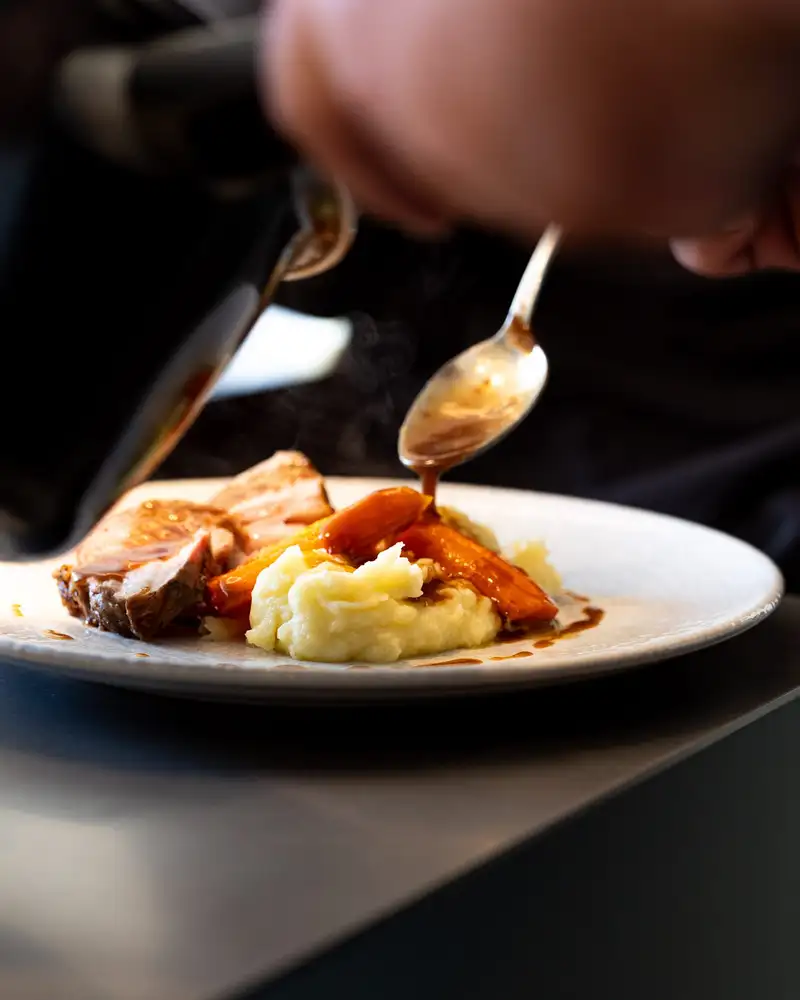 Chef dressant une assiette lors d'un déjeuner privé à l'Atelier Qu4tre-Qu4rts, location de cuisine à Bordeaux