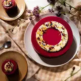 Entremets de fête au glaçage rouge décoré de fleurs comestibles, gâteau sur commande de la pâtisserie Quatre-Quarts à Bordeaux