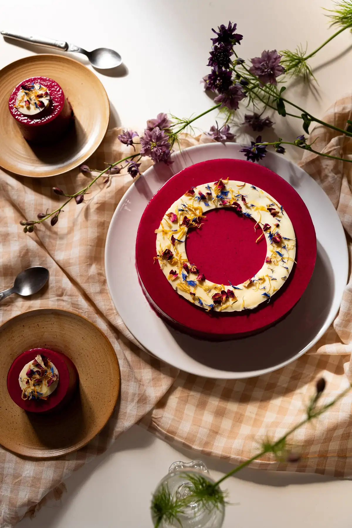 Entremets de fête au glaçage rouge décoré de fleurs comestibles, gâteau sur commande de la pâtisserie Quatre-Quarts à Bordeaux