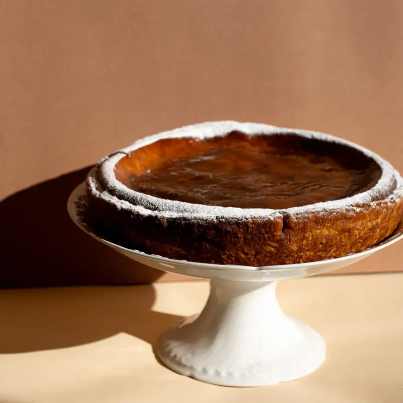 Flan pâtissier sans œufs saupoudré de sucre glace sur un présentoir, pâtisserie Quatre-Quarts à Bordeaux