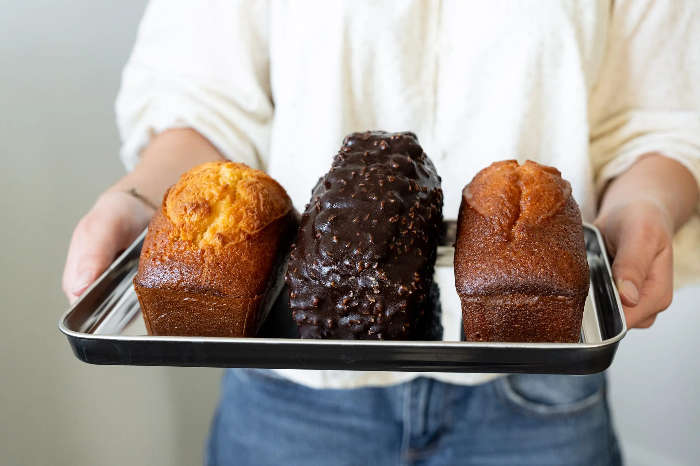 Trois quatre-quarts présentés sur un plateau, dont un enrobé de chocolat, boulangerie Quatre-Quarts à Bordeaux