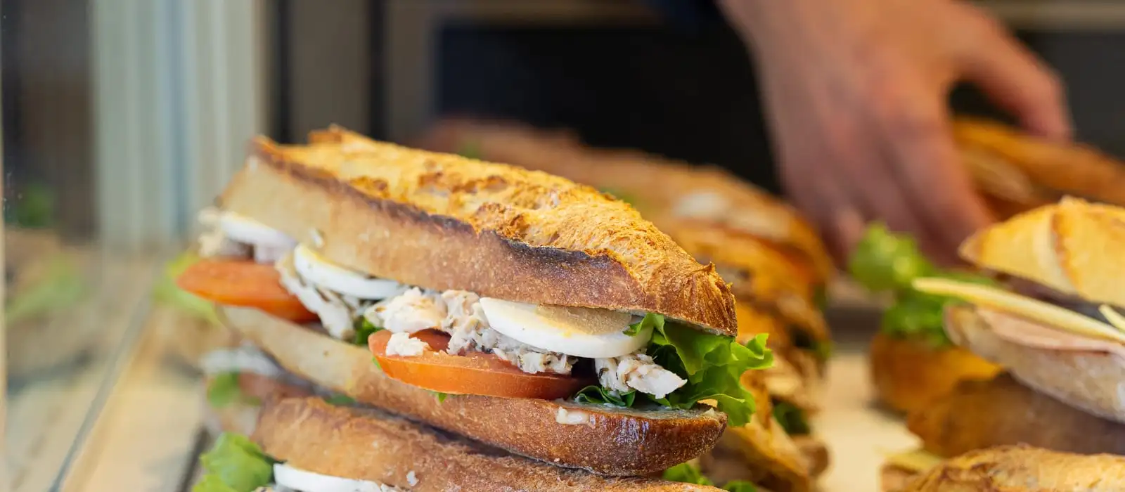Sandwichs garnis disposés en vitrine, snacking de la boulangerie Quatre-Quarts à Bordeaux